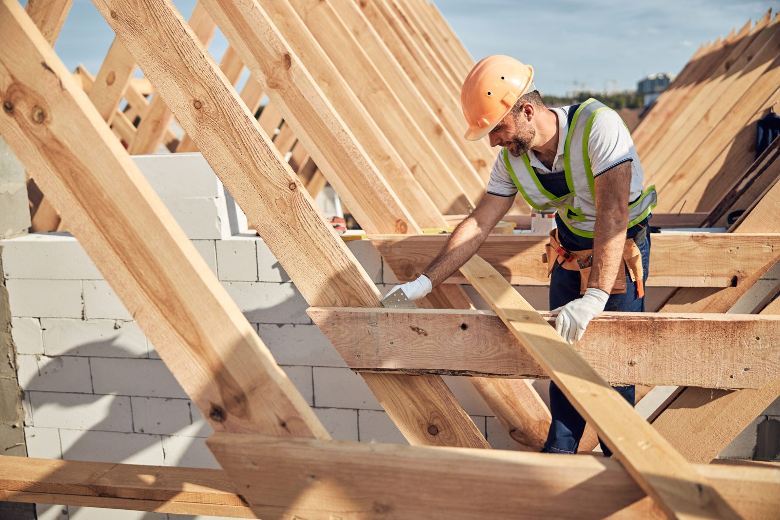 Zimmerer arbeitet an der Holzkonstruktion eines Dachstuhls