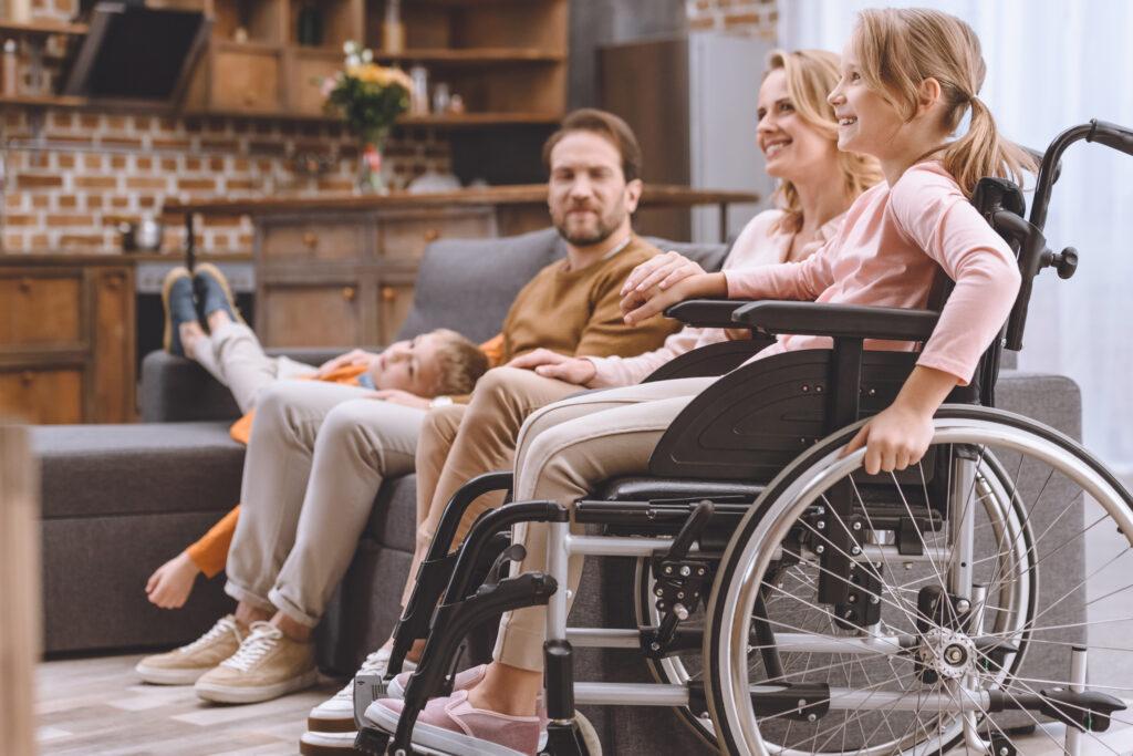 Familie mit Tochter im Rollstuhl zu Hause